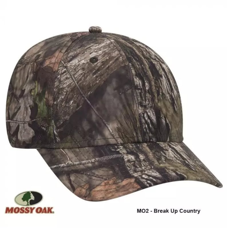 Op de afbeelding: Een camouflage baseballpet met een Mossy Oak logo. De pet is gelabeld "MO2 - Break Up Country".