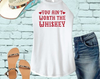 May include: White tank top with a red graphic that says "YOU AIN'T WORTH THE WHISKEY" with red hearts on either side of the text.