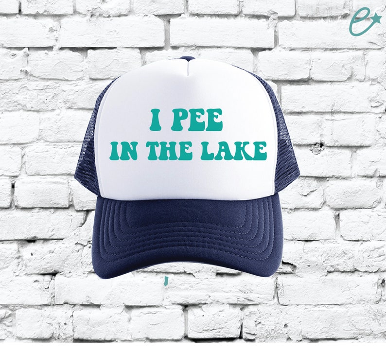 May include: A white and blue trucker hat with the text "I PEE IN THE LAKE" in teal.