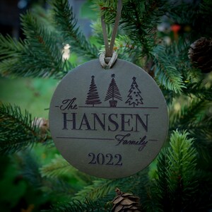 May include: A green leather Christmas ornament with three stylized trees, the text "The Hansen Family 2022" and a star.
