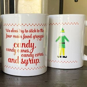 May include: White ceramic mug with a red and white design. The mug features a cartoon elf and the text "We elves try to stick to the four main food groups: candy, candy canes, candy corns, and syrup."