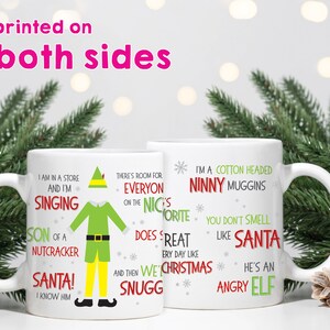 May include: Two white ceramic mugs with humorous quotes from the movie Elf. One mug features a green elf graphic and quotes like "I'm singing" and "Son of a Nutcracker." The other mug says "I'm a cotton headed ninny muggins."