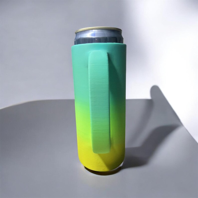 May include: A teal and yellow gradient can cooler with a handle, holding a silver can. The cooler is designed to keep beverages cold. The handle provides a comfortable grip for easy carrying.