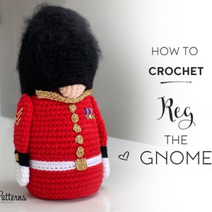 Puede incluir: Patrón de crochet para un gnomo rojo y negro con sombrero y uniforme, titulado "Cómo hacer crochet a Reg el gnomo".