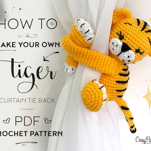 May include: Crochet pattern for a cute yellow tiger curtain tie back. The pattern is available as a PDF download. The image shows the finished tiger holding onto a white curtain.