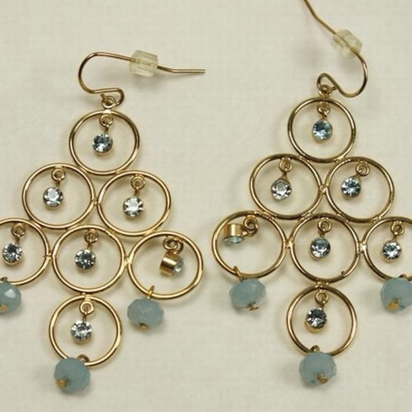 Beautiful & Exotic goldtone openwork chandelier style earrings with light blue rhinestones and beads.