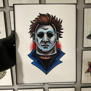 May include: A white ceramic mug with a black handle and the text "But First, Coffee" in a bold, black font. The mug is set against a blurred background, suggesting a cozy setting.