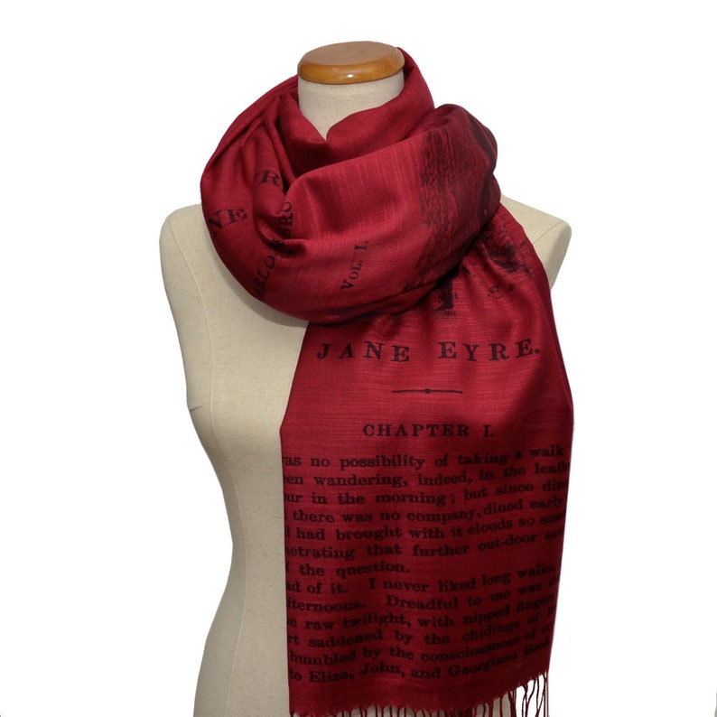May include: A red scarf with a black print of the first chapter of Jane Eyre. The text includes the title "Jane Eyre" and "Chapter I".