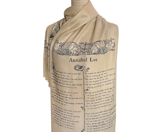 Può includere: Una sciarpa beige con testo nero che presenta la poesia "Annabel Lee" di Edgar Allan Poe. La poesia è stampata in un carattere decorativo e incorniciata da motivi floreali.
