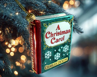 May include: A Christmas Carol Christmas tree ornament shaped like a book. The ornament has a green cover with the title in red and white, and snowflakes. The spine is red with the title. The author's name, Charles Dickens, is at the bottom.