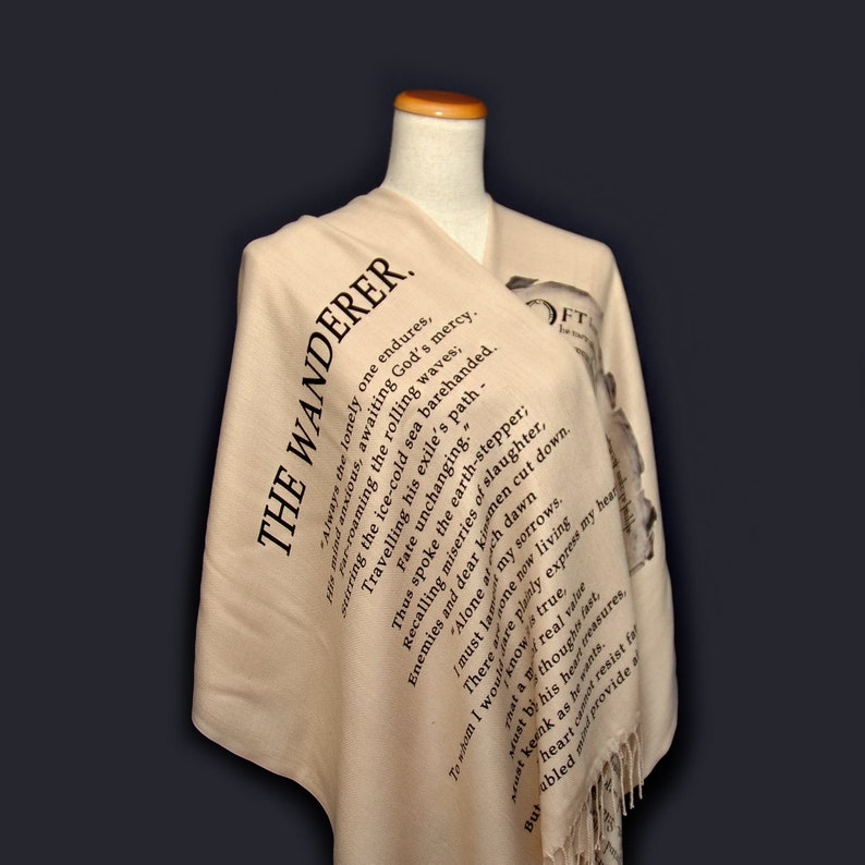May include: A beige shawl with black text printed on it. The text is a poem titled "The Wanderer".