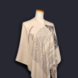 May include: A beige shawl with a black and white print of the first chapter of "Wuthering Heights" by Emily Bront&euml;. The shawl has a fringe border.