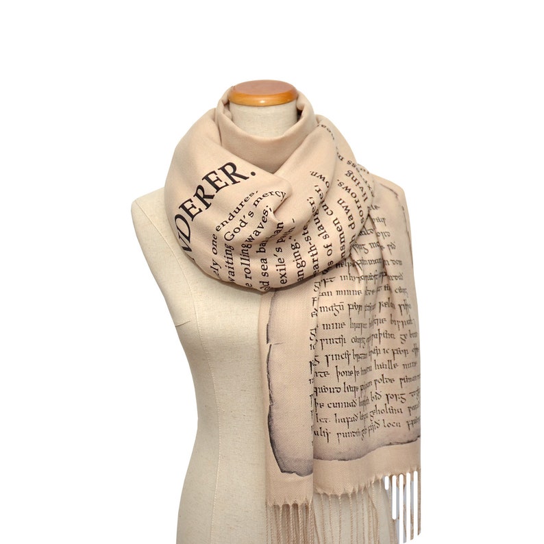 May include: A beige scarf with black text printed on it. The text reads "WANDERER... waiting for one endures... God's mercy... rolling waves... old sea bars... exile's ban... Earth-stealing..."