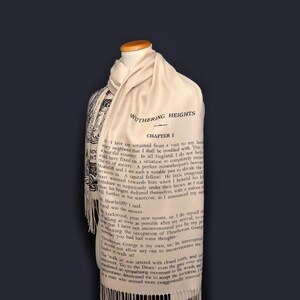May include: A beige scarf with a black and white print of the first page of the book "Wuthering Heights" by Emily Bront&euml;. The text on the scarf reads "WUTHERING HEIGHTS - CHAPTER I".