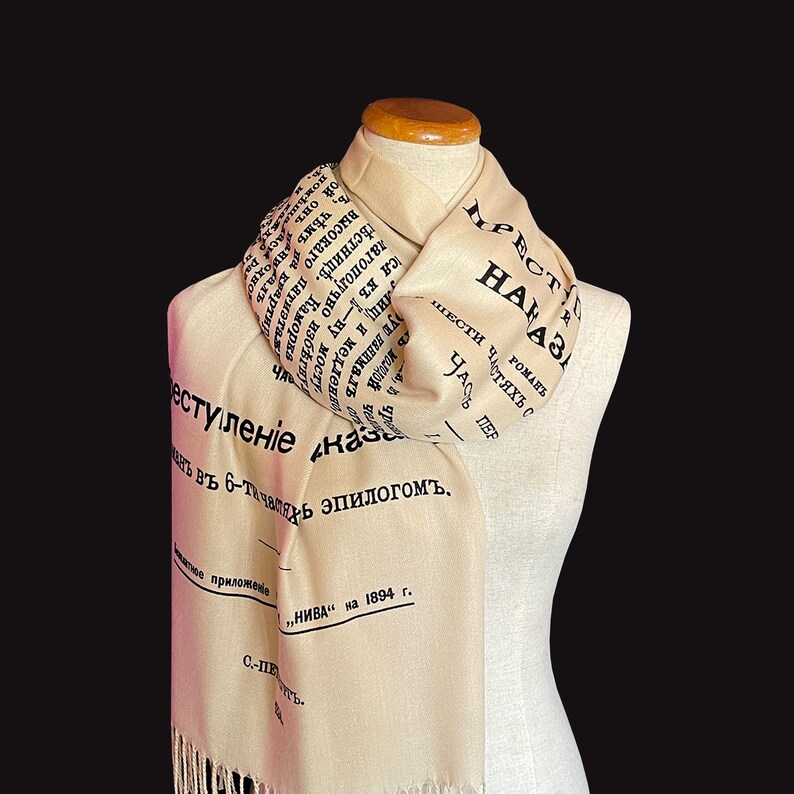 May include: A beige scarf with black text that reads "Введение в 6-ти главах эпилогом, "Нива" на 1894 г." and "РОМАНЬ ШЕСТИ ЧАСТЯХЪ С ЧАСТЬ ПЕРВ",  a Russian novel.