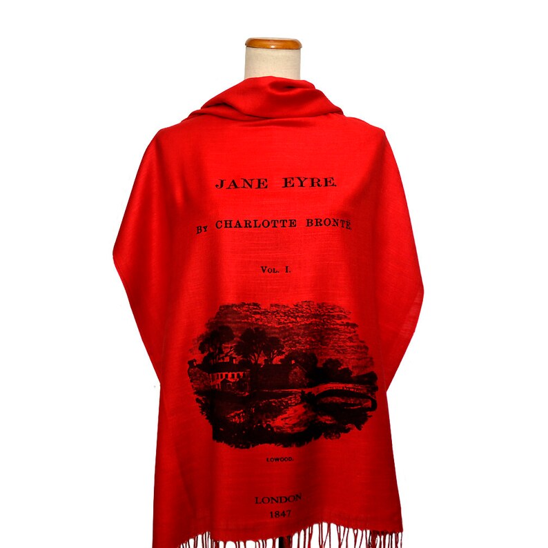 May include: Red scarf with a black print of the book cover for "Jane Eyre" by Charlotte Bronte. The cover features the title, author, volume number, and a black and white illustration.