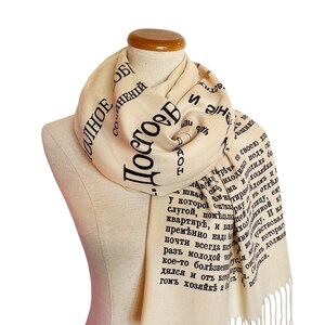 May include: A cream-colored scarf with black text printed on it. The text is in Russian and reads "Posove" and "Olnnoe Sochineniy".