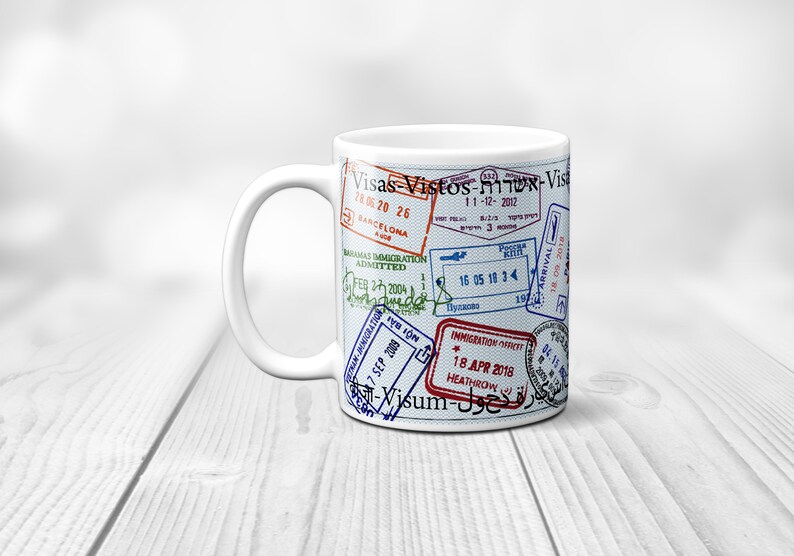 May include: White ceramic mug with a design of various passport stamps and the text "Visas Vistos-שרות-Vist" printed on it.