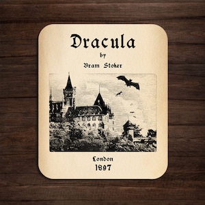 May include: A vintage book cover for Dracula by Bram Stoker. The cover features a black and white illustration of a castle with bats flying overhead. The text "Dracula" is in a gothic font and the text "by Bram Stoker" is below it. The text "London 1897" is at the bottom of the cover.