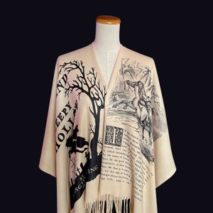 May include: A beige shawl with black text and illustrations. The text reads "Sleepy Hollow" and includes an excerpt from Washington Irving's "The Legend of Sleepy Hollow".