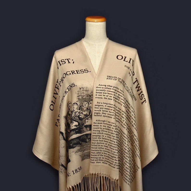 May include: A beige shawl with black text and an illustration from Charles Dickens's "Oliver Twist". The text includes the title of the book and the chapter "Treats of the Poor Law, and of the Circumlocution Office".