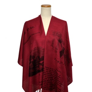 May include: A red shawl with a black print of a book cover and text that reads "Jane Eyre" by Charlotte Bronte. The text is from the book and includes a quote from the story.