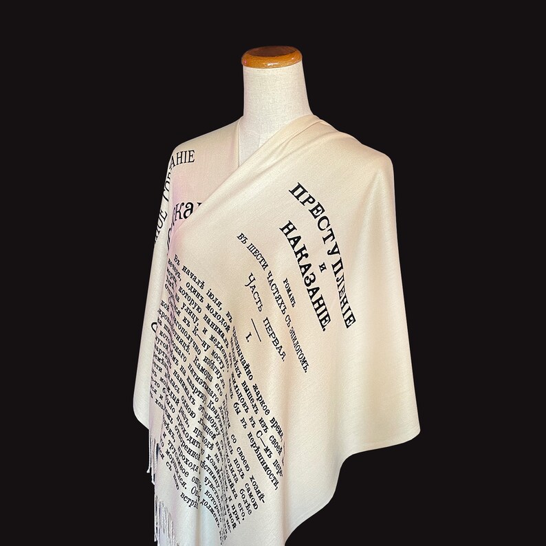 May include: A white scarf with black text that reads "Преступление и наказание" (Crime and Punishment) in Russian. The text is from the title page of the novel by Fyodor Dostoevsky.