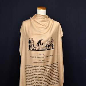 May include: A beige silk scarf with a black and white illustration of a scene from the book "The Brothers Karamazov" by Fyodor Dostoevsky. The text on the scarf reads "Part I, Book I - The History of a Family, Chapter I, Fyodor Pavlovitch Karamazov".