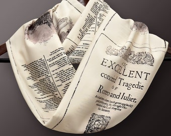 May include: A cream-colored scarf with black text printed on it. The text reads "The Excellent Conced Tragédie of Romeo and Juliet." The scarf is folded and hanging from a wooden hanger.