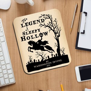May include: A black and white mousepad with a spooky illustration of the Headless Horseman riding a horse through a graveyard. The text reads "The Legend of Sleepy Hollow by Washington Irving 1820".