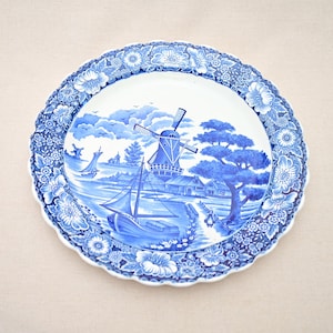 Gran plato de loza con decoración de flores de color azul cobalto, molinos de viento, islas japonesas con barcos