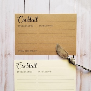 May include: Two blank recipe cards with brown and cream paper. The cards have the words "Cocktail", "Ingredients", and "Directions" printed on them. The cards are designed for writing down cocktail recipes.