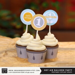 Può includere: Fodere per cupcake stampabili a tema mongolfiera. Le fodere sono grigie con pois bianchi e un disegno di mongolfiere. Le fodere sono decorate con il testo "Oh, how time flies" e "Happy Birthday".