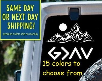 May include: White vinyl decal with a mountain range and the text "G>AV" and "15 colors to choose from". The decal is on the back window of a white Jeep.