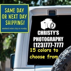 May include: A white Jeep with a black and white photography business decal on the back window. The decal features a camera icon, the text "CHRISTY'S PHOTOGRAPHY", a phone number, and the text "15 colors to choose from".