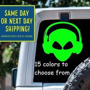 May include: A white Jeep with a green alien wearing headphones sticker on the back window. The sticker says "15 colors to choose from".