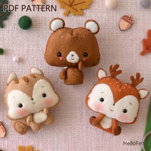 Puede incluir: Un patrón PDF de fieltro con tres figuras de animales del bosque: un oso pardo, una ardilla marrón y un ciervo con manchas blancas. El oso está de pie, mientras que la ardilla y el ciervo están sentados. El texto "PDF PATTERN" está en la parte superior.