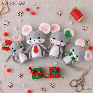 May include: Four gray felt mice with white bellies and pink-lined ears are arranged on a neutral surface. Each mouse has a different accessory: a red bow, a red tie, a red and white striped collar, and a green scarf. Two small gift boxes and wooden snowflakes are also present.
