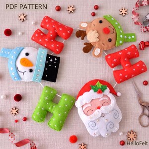 Könnte beinhalten: Eine Weihnachts-Girlande aus Filz mit einem Schneemann, Rentier, Weihnachtsmann und roten und grünen Buchstabenformen. Die Girlande enthält oben den Text "PDF PATTERN" und unten rechts "HelloFelt".