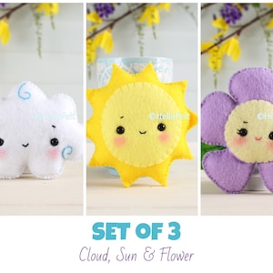 May include: Set of three felt toys: a white cloud, a yellow sun, and a purple flower. Each toy has a smiling face and is handmade.