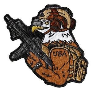Puede incluir: Parche bordado con un águila marrón que lleva un casco y sostiene un rifle negro. El águila tiene un pecho blanco con un diseño de rayo y la palabra "USA" es visible en su brazo.