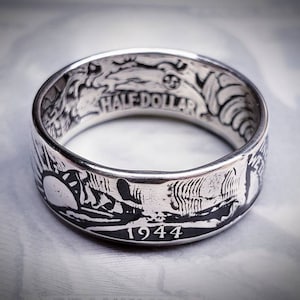 Könnte beinhalten: Ein silberner Ring aus einer 50-Cent-Münze von 1944. Der Ring trägt die Inschrift "HALF DOLLAR" und das Jahr "1944".