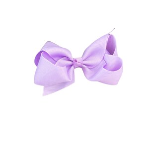 May include: A large, lavender-colored bow made of ribbon. The bow is tied in a classic style with two loops and a center knot.