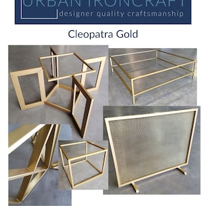 May include: A set of gold metal furniture pieces, including a coffee table, end table, and a fireplace screen. The furniture is made of a sturdy metal frame with a mesh design. The text "URBAN IRONCRAFT" and "designer quality craftsmanship" is displayed above the title "Cleopatra Gold". The text "As close to a soft brass as you can get!" is displayed below the image.