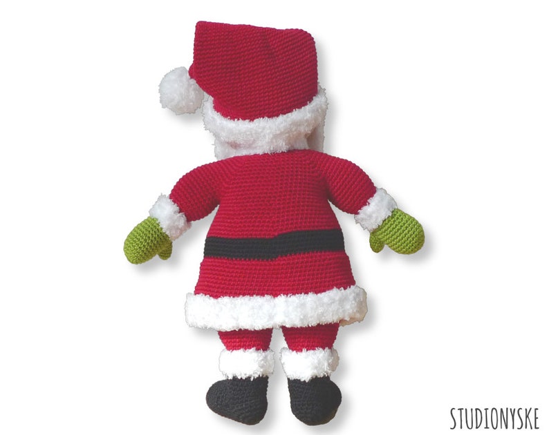 May include: A crocheted Santa Claus doll with a red suit, white trim, black belt, green mittens, and black boots. The doll is facing away from the camera.