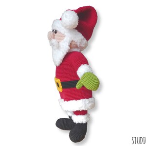 May include: A crocheted Santa Claus doll with a red suit, white beard, and black boots. The doll is wearing a green mitten on one hand and has a black belt with a yellow buckle.