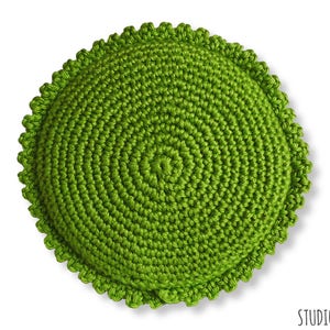 Puede incluir: Un coj&iacute;n redondo de crochet de color verde con un borde festoneado.