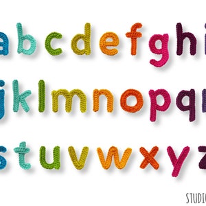 May include: A collection of colorful, crocheted lowercase letters of the alphabet, each in a different hue. The letters are arranged in three rows against a white background. The letters are in shades of blue, green, yellow, orange, pink, and purple.