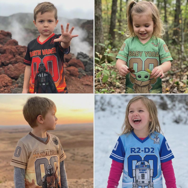 Pu&ograve; includere: Quattro bambini indossano maglie a tema Star Wars. Le maglie presentano Darth Vader, Baby Yoda, The Mandalorian e R2-D2. Ogni maglia ha il numero "00" sul davanti. I bambini si trovano in vari ambienti esterni.