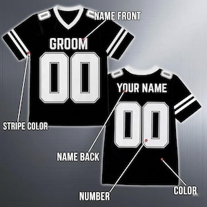Op de afbeelding: Zwart voetbalshirt met witte accenten, met het woord "GROOM" op de voorkant en het nummer "00". De achterkant van het shirt toont "YOUR NAME" en het nummer "00". Witte strepen sieren de mouwen.
